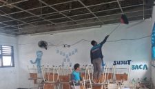 Petugas membersihkan puing plafon ruang kelas SMPN 60 Surabaya yang runtuh akibat tekanan angin.