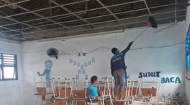 Petugas membersihkan puing plafon ruang kelas SMPN 60 Surabaya yang runtuh akibat tekanan angin.