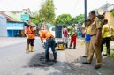 Petugas Satgas Jalan Berlubang melakukan penambalan aspal menggunakan hotmix di salah satu ruas jalan perkotaan di Banyuwangi, Kamis (5/2/2026).