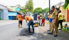 Petugas Satgas Jalan Berlubang melakukan penambalan aspal menggunakan hotmix di salah satu ruas jalan perkotaan di Banyuwangi, Kamis (5/2/2026).
