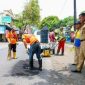 Petugas Satgas Jalan Berlubang melakukan penambalan aspal menggunakan hotmix di salah satu ruas jalan perkotaan di Banyuwangi, Kamis (5/2/2026).