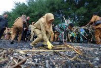 Bupati Banyuwangi Ipuk Fiestiandani bersama jajaran Forkopimda dan ribuan peserta melakukan aksi bersih pantai usai deklarasi Banyuwangi ASRI di Grand Watu Dodol.