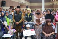 Gubernur Jawa Timur Khofifah Indar Parawansa didampingi Bupati Probolinggo Mohammad Haris menyerahkan bantuan sosial kepada penerima manfaat di Auditorium Madakaripura, Kabupaten Probolinggo, Senin (23/2/2026).