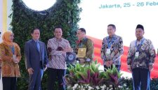 Hanif Faisol Nurofiq menyerahkan penghargaan kepada Wali Kota Surabaya Eri Cahyadi pada Rakornas Pengelolaan Sampah 2026 di Jakarta.