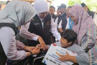 Gubernur Jawa Timur Khofifah Indar Parawansa menyerahkan bantuan sosial secara simbolis kepada warga di Kantor Kecamatan Glenmore, Banyuwangi, Sabtu (28/2/2026).