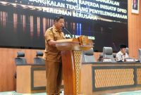 Sekda Bangkalan Ismet Efendi menyampaikan nota pendapat Bupati dalam Sidang Paripurna DPRD terkait Raperda Penyelenggaraan Perizinan Berusaha di Daerah, Senin (2/3/2026).