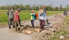 Babinsa Desa Guworejo Koramil 02/Karangmalang Kodim 0725/Sragen Sumartana bersama warga melaksanakan kerja bakti menguruk bahu jalan yang rusak di Desa Guworejo, Kabupaten Sragen, Senin (09/03/2026).