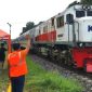 Petugas Jaga Lintasan Ekstra (PJL) berjaga di perlintasan sebidang kereta api tanpa palang pintu di Banyuwangi untuk mengatur lalu lintas dan memastikan keselamatan pengguna jalan selama periode Angkutan Lebaran 2026.