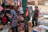 Babinsa Desa Gesi Koramil 12/Gesi Kodim 0725/Sragen Sertu Heri memeriksa makanan dan bahan pokok yang dijual pedagang saat melakukan pemantauan keamanan pangan di Pasar Desa Gesi, Kecamatan Gesi, Sragen, Kamis (12/3/2026).