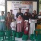 Penasehat Hukum dan jajaran redaksi Media Liputan7.id saat menyerahkan santunan kepada anak yatim dan dhuafa dalam kegiatan sosial di Aula Balai Desa Pandian, Kabupaten Sumenep.