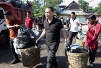 Wali Kota Surabaya Eri Cahyadi saat meninjau TPS dan turut mengangkut sampah dalam kerja bakti serentak pegawai Pemkot Surabaya, Rabu (1/4/2026).