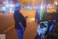 Petugas kepolisian melakukan olah TKP kecelakaan antara truk bermuatan cabai dan sepeda motor Honda Scoopy di Jalan Raya Torjun, Sampang, Minggu (5/4/2026) dini hari.