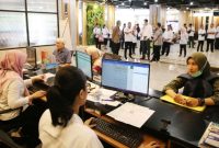 Petugas melakukan pelayanan administrasi kependudukan di Surabaya. Pemkot mulai memberlakukan penangguhan akses layanan bagi warga yang belum melakukan konfirmasi data DTSEN 2025.