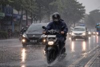 Ilustrasi pengendara melintas di tengah hujan deras, seiring peringatan BMKG terkait potensi hujan lebat di sejumlah wilayah Indonesia.