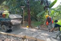 Pekerja tengah meratakan adukan beton dalam proyek rabat jalan lingkungan di Gang H. Ilham, Desa Cikopo, Purwakarta.
