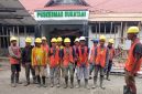 Para pekerja proyek mengikuti briefing dan doa bersama sebelum memulai pekerjaan renovasi Puskesmas Sukatani.