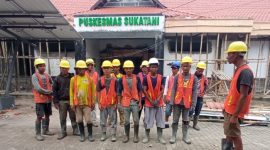 Para pekerja proyek mengikuti briefing dan doa bersama sebelum memulai pekerjaan renovasi Puskesmas Sukatani.