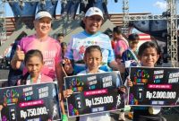 Bupati Sumenep Achmad Fauzi Wongsojudo dan Ketua Panitia Go Sumenep Purnama Fun Run 2026, Dela Maulana Ansyar foto bersama tiga peserta cilik menunjukkan hadiah uang tunai usai meraih juara dalam ajang lari 5 kilometer di GOR A. Yani Pangligur, Sumenep, Minggu (30/8/2026). 