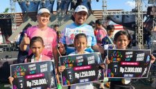Bupati Sumenep Achmad Fauzi Wongsojudo dan Ketua Panitia Go Sumenep Purnama Fun Run 2026, Dela Maulana Ansyar foto bersama tiga peserta cilik menunjukkan hadiah uang tunai usai meraih juara dalam ajang lari 5 kilometer di GOR A. Yani Pangligur, Sumenep, Minggu (30/8/2026).