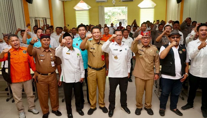 Sejumlah pejabat dan peserta kegiatan berfoto bersama dengan mengangkat tangan sebagai bentuk semangat kebersamaan dalam kegiatan di Banyuwangi.