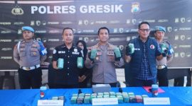 Petugas Satresnarkoba Polres Gresik menunjukkan barang bukti ganja seberat 10,858 kilogram yang disembunyikan di dalam komponen sepeda motor Vespa di sebuah gudang ekspedisi di Kecamatan Cerme, Gresik.