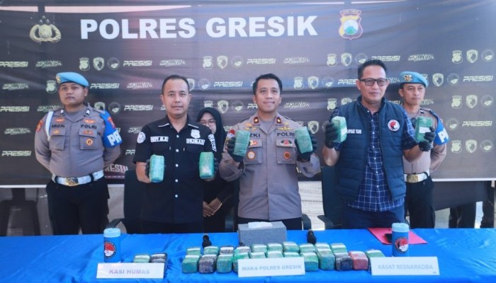 Petugas Satresnarkoba Polres Gresik menunjukkan barang bukti ganja seberat 10,858 kilogram yang disembunyikan di dalam komponen sepeda motor Vespa di sebuah gudang ekspedisi di Kecamatan Cerme, Gresik.