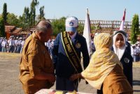 Kepala SMKN 1 Kalianget Zainul Sahari menyematkan selendang kepada Ketua OSIS periode 2026–2027 Jaya Laksmana saat pelantikan, Senin (5/10/2026).