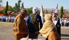Kepala SMKN 1 Kalianget Zainul Sahari menyematkan selendang kepada Ketua OSIS periode 2026–2027 Jaya Laksmana saat pelantikan, Senin (5/10/2026).