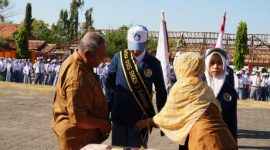 Kepala SMKN 1 Kalianget Zainul Sahari menyematkan selendang kepada Ketua OSIS periode 2026–2027 Jaya Laksmana saat pelantikan, Senin (5/10/2026).