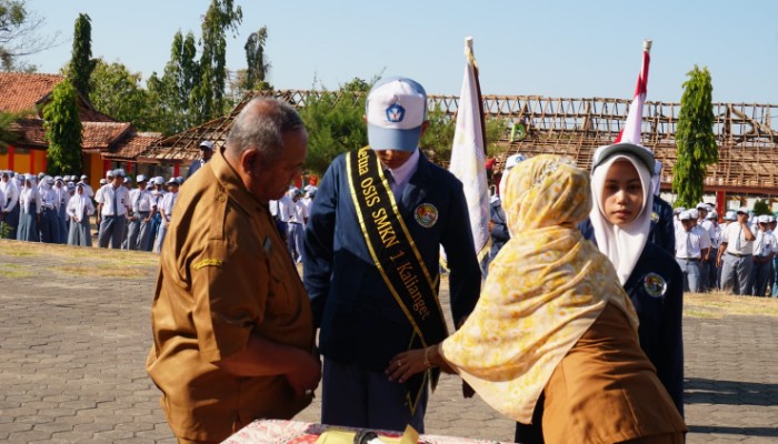 Kepala SMKN 1 Kalianget Zainul Sahari menyematkan selendang kepada Ketua OSIS periode 2026–2027 Jaya Laksmana saat pelantikan, Senin (5/10/2026).