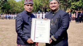 Bupati Bangkalan Lukman Hakim menyerahkan sertifikat penghargaan kepada Hizbur Rahman, perwakilan PT TASPEN (Persero) Kantor Cabang Pamekasan, sebagai mitra strategis jaminan sosial dan program Personal Accident (PA) 5000 bagi ASN, Jumat (23/10/2026). (Dok. PT TASPEN)
