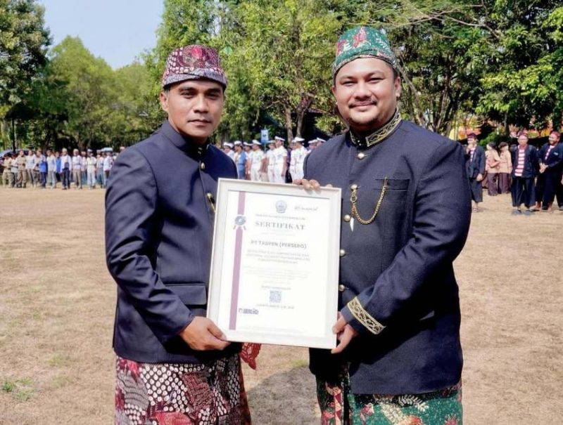 Bupati Bangkalan Lukman Hakim menyerahkan sertifikat penghargaan kepada Hizbur Rahman, perwakilan PT TASPEN (Persero) Kantor Cabang Pamekasan, sebagai mitra strategis jaminan sosial dan program Personal Accident (PA) 5000 bagi ASN, Jumat (23/10/2026). (Dok. PT TASPEN)
