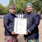 Bupati Bangkalan Lukman Hakim menyerahkan sertifikat penghargaan kepada Hizbur Rahman, perwakilan PT TASPEN (Persero) Kantor Cabang Pamekasan, sebagai mitra strategis jaminan sosial dan program Personal Accident (PA) 5000 bagi ASN, Jumat (23/10/2026). (Dok. PT TASPEN)